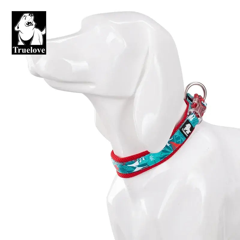 White ceramic or plastic dog figurine wearing a colorful collar.