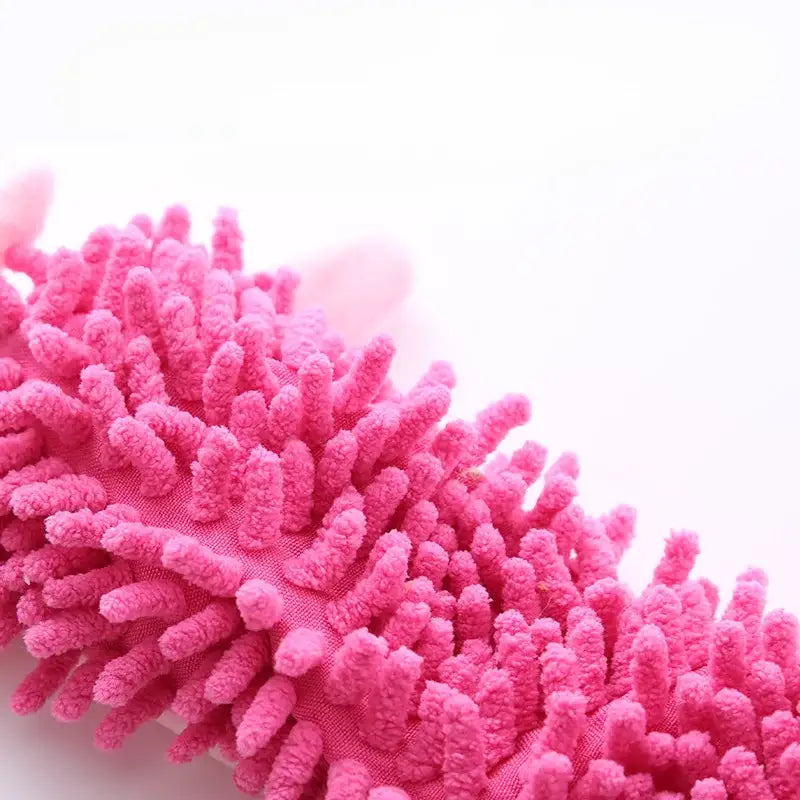 Bright pink microfiber duster or cleaning mop head with fluffy tendrils.