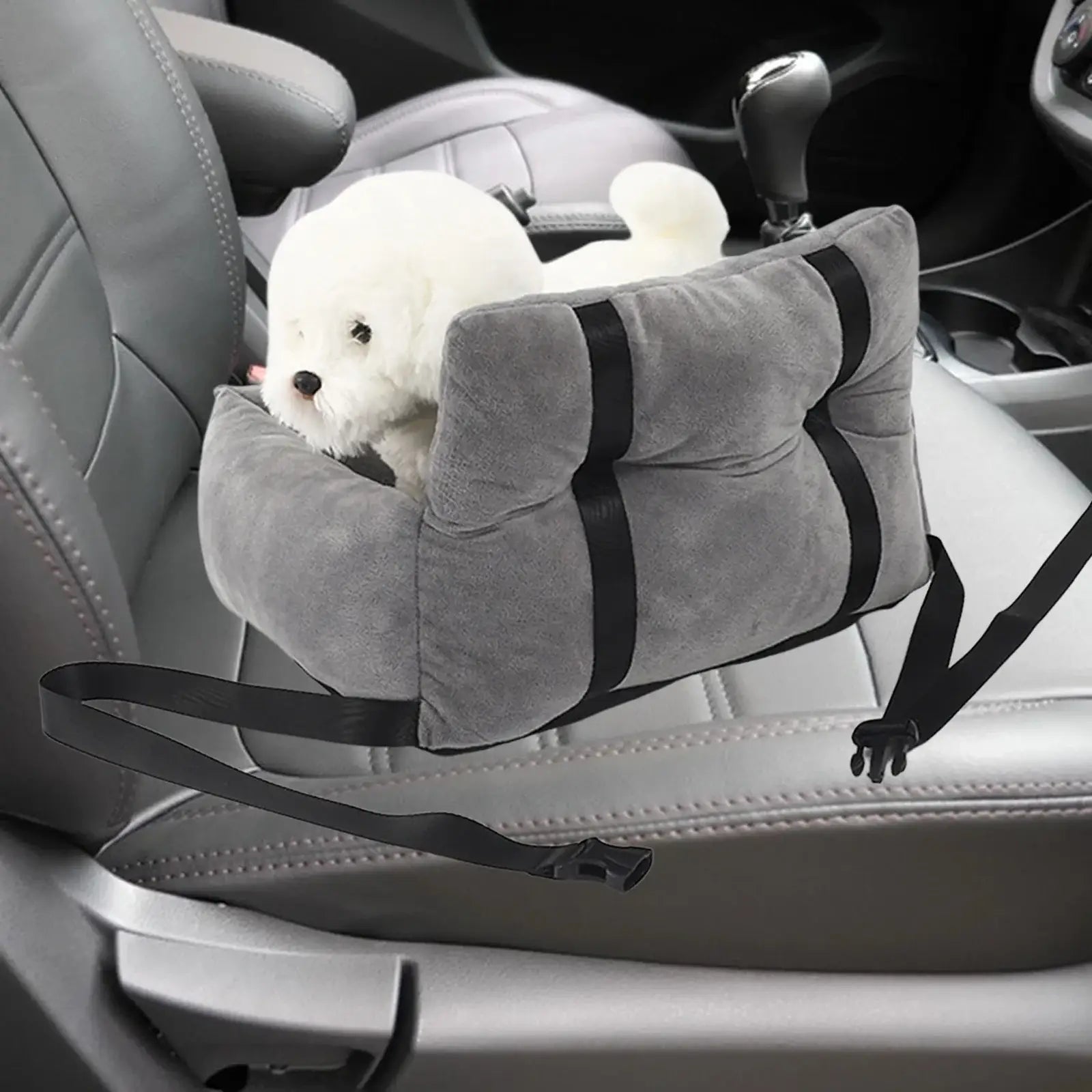 Plush white dog peeking out of a gray pet car seat.