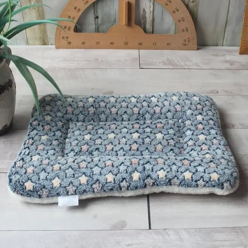 Chunky knitted or crocheted blue-gray cushion or pet bed with a textured surface.