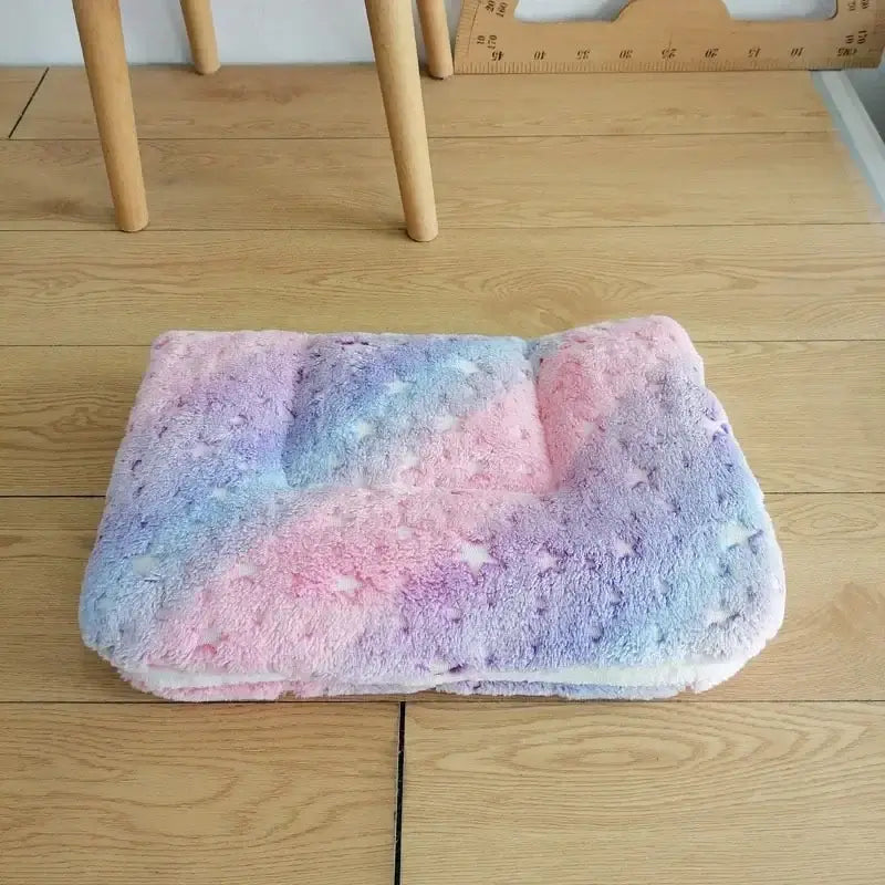 Fluffy, pastel-colored cushion or pillow with pink, blue, and purple hues.