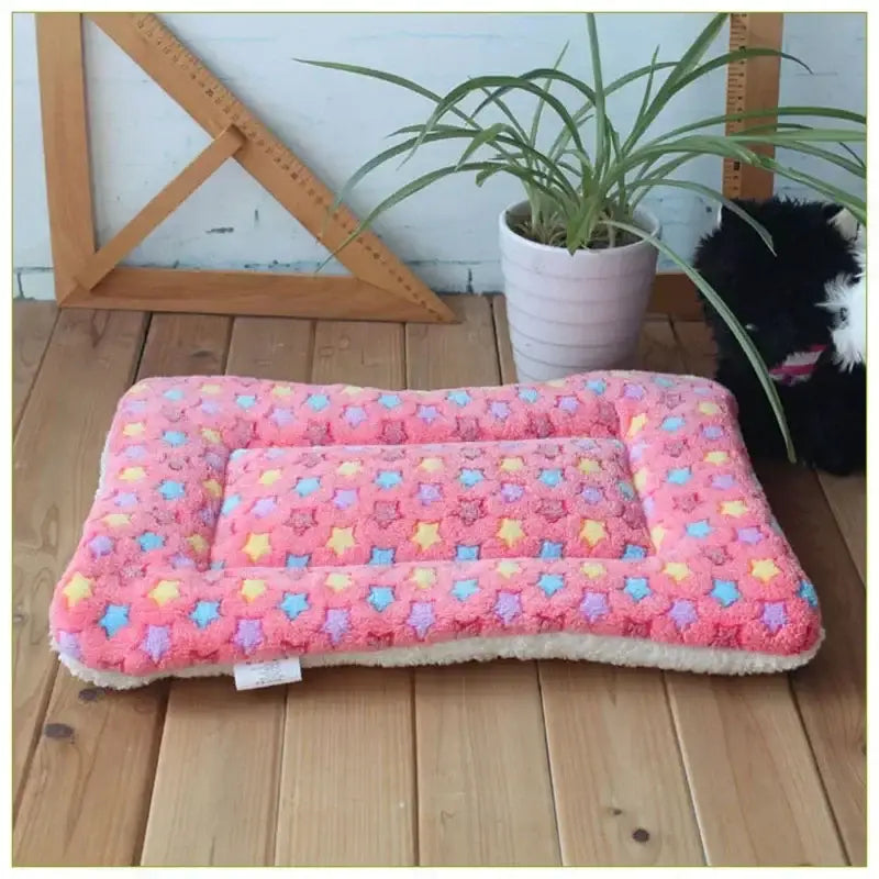 Pink patterned pet bed with colorful paw print design.