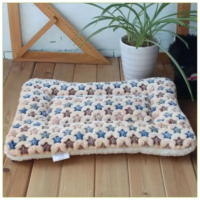 Plush pet bed with a star-patterned cushion in cream, blue, and brown tones.