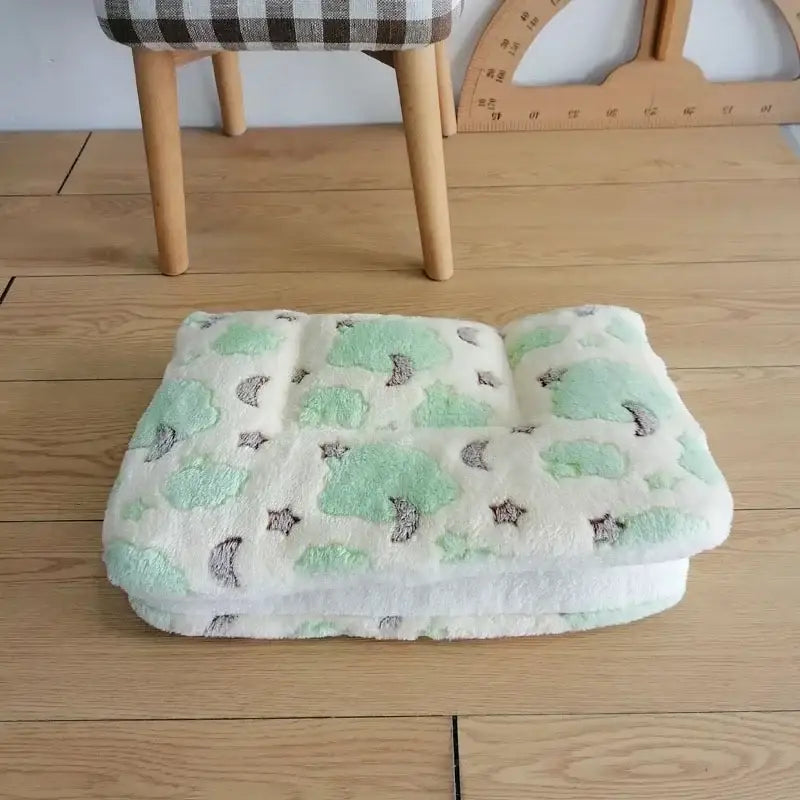 Soft blanket or mat with mint green and gray animal patterns.