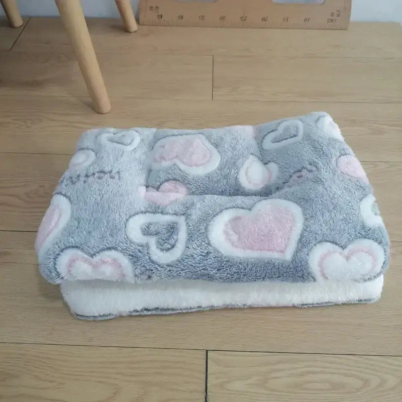 Soft gray pet bed with pink and white heart patterns.