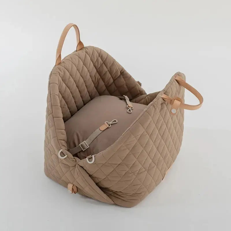 Quilted beige handbag with leather straps and a padded interior.