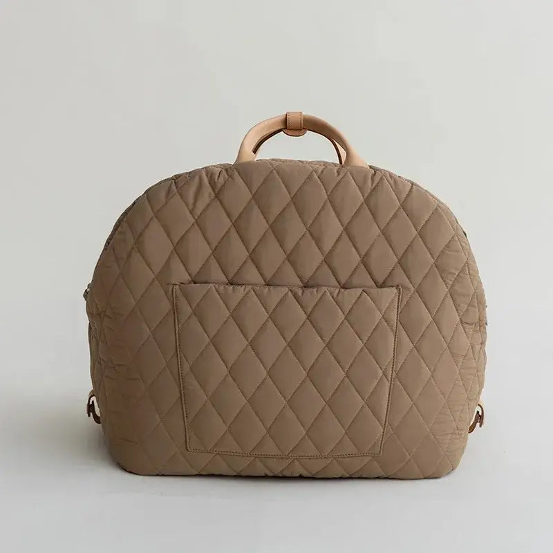 Quilted beige handbag with a curved top and circular handle.