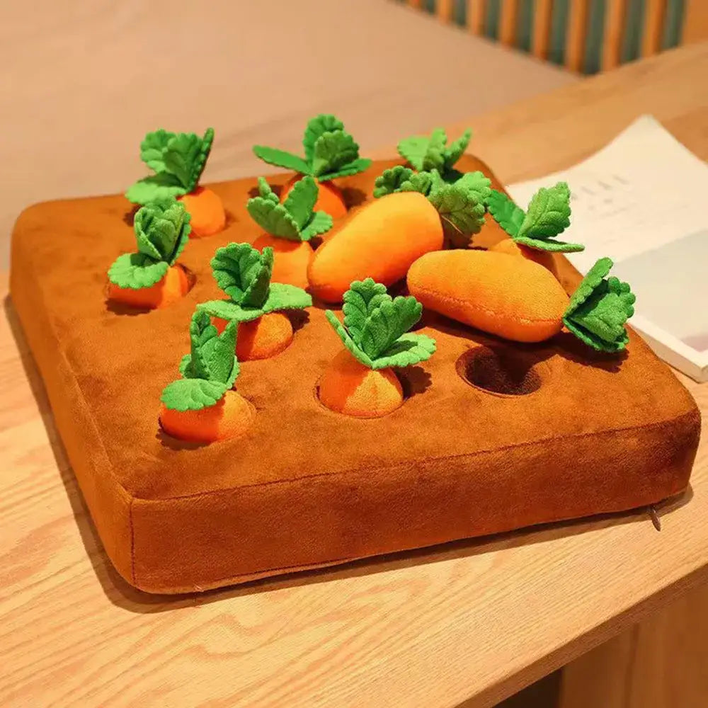 Plush toy garden bed with fabric carrots and leafy tops.