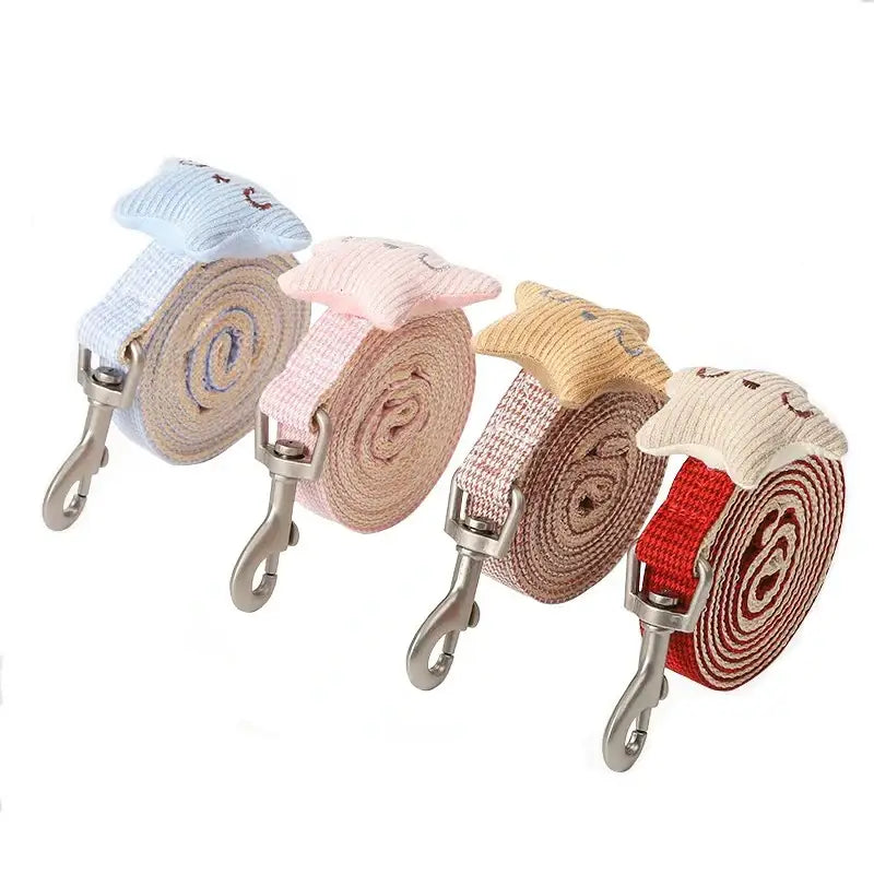 Collection of rolled-up fabric dog leashes in various pastel colors with metal clasps.