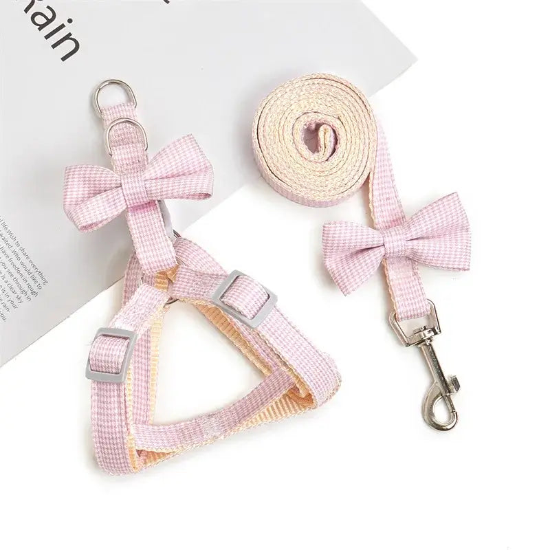 Pink gingham dog harness and leash set with decorative bows.