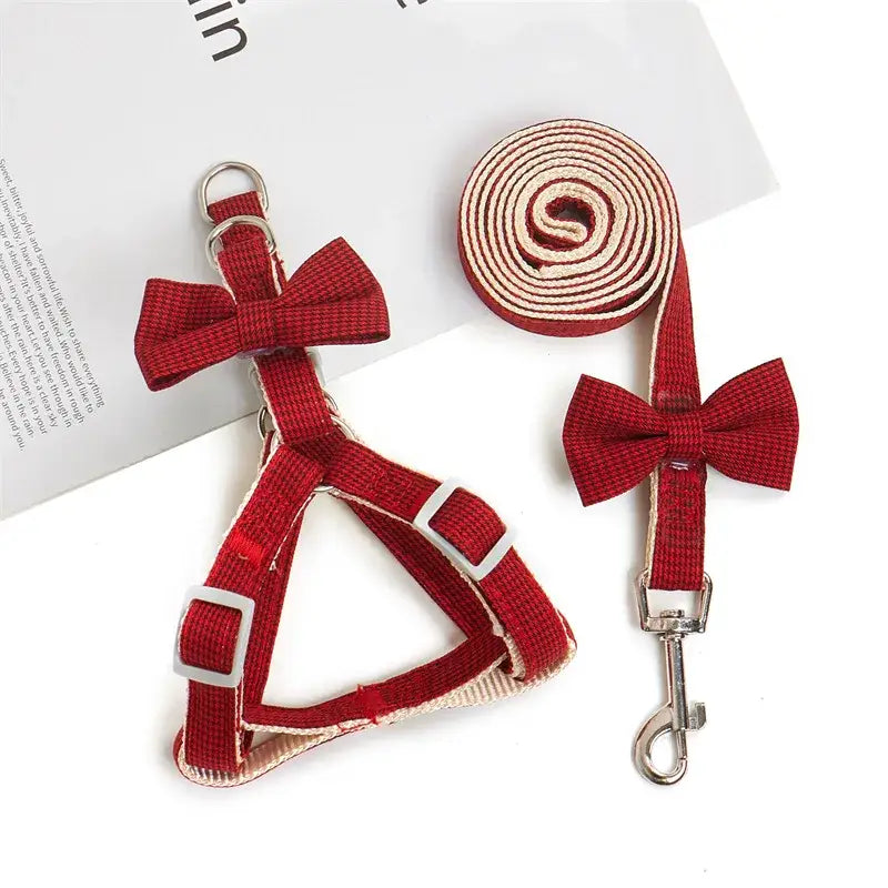 Red dog harness and leash set with decorative bows.