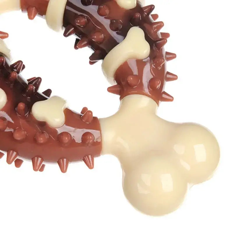 Bone-shaped dog treat with spiky rubber rings around it.