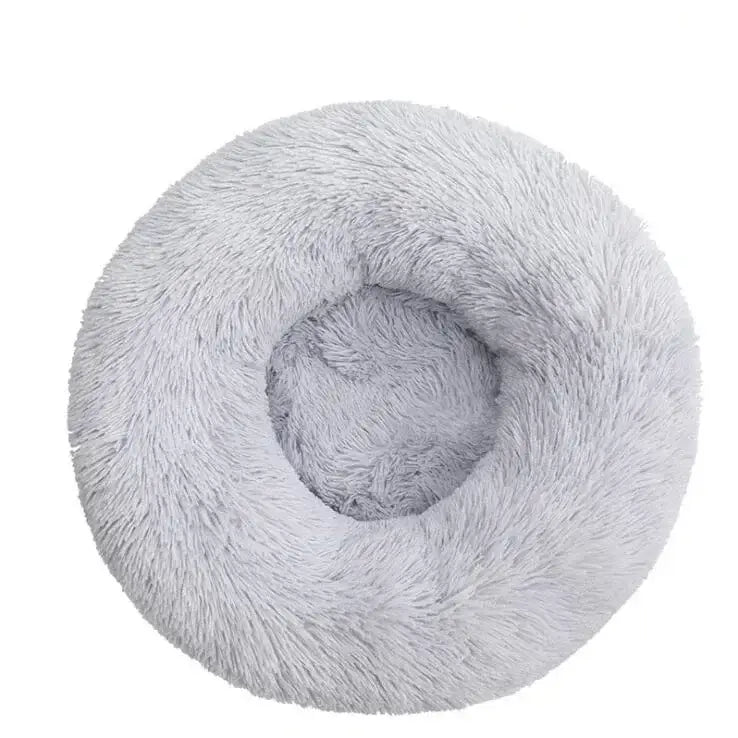 Circular, fluffy pet bed with a plush, light gray surface and a sunken center.