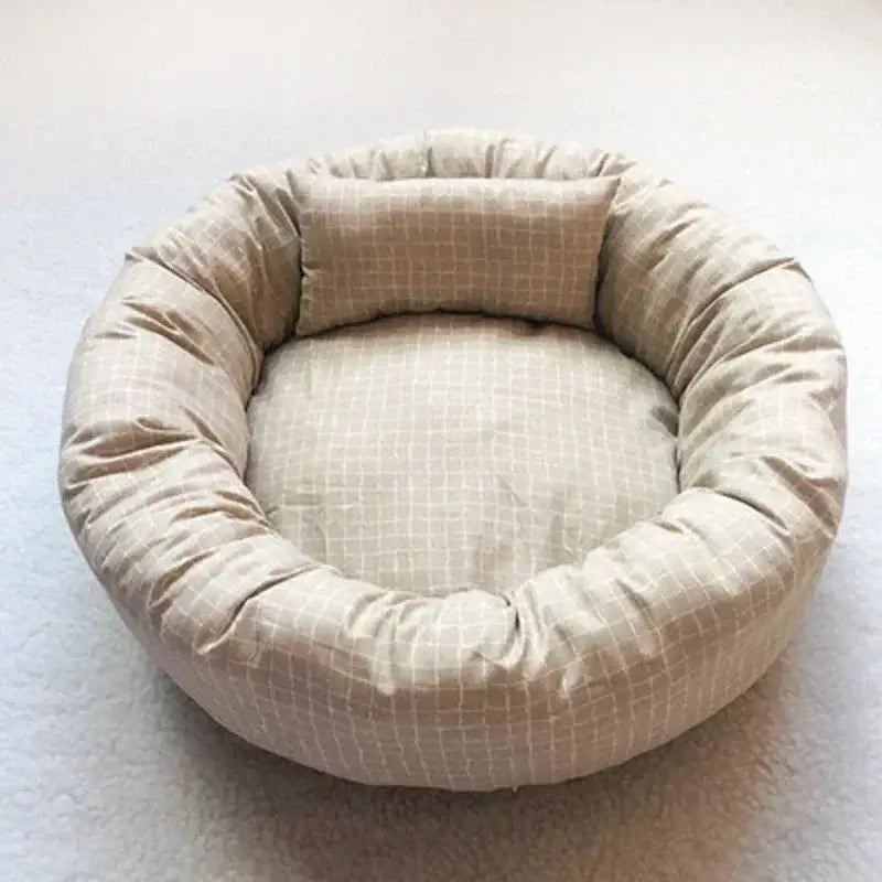 Circular beige pet bed with a plush, padded rim and cushioned interior.