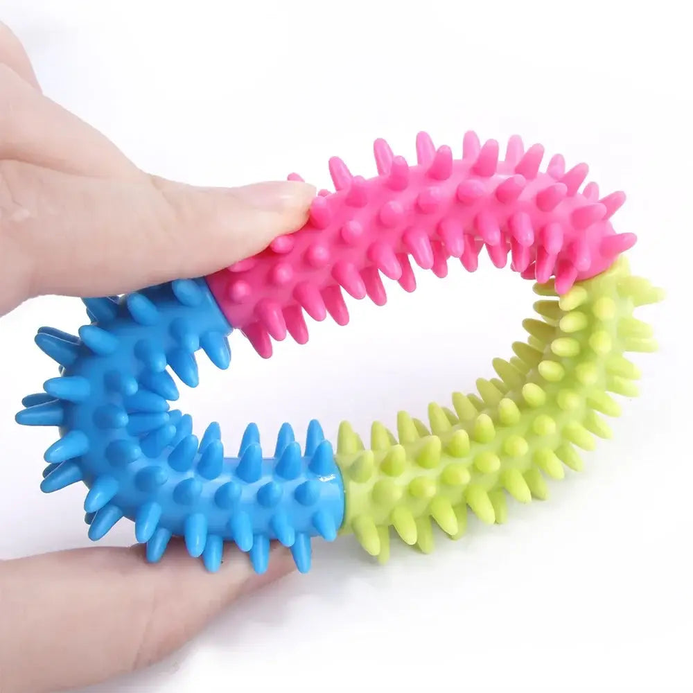 Colorful spiked rubber ring toy held by hands.