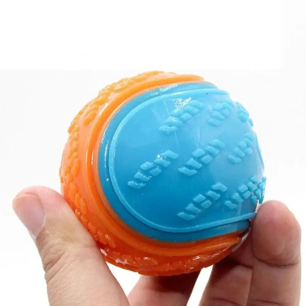 Two-toned rubber ball with textured patterns held between fingers.