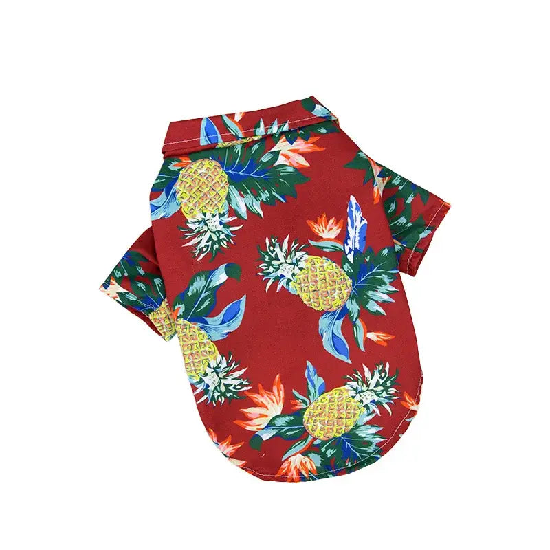 Hawaiian-style shirt with a vibrant pineapple and tropical floral print on a red background.