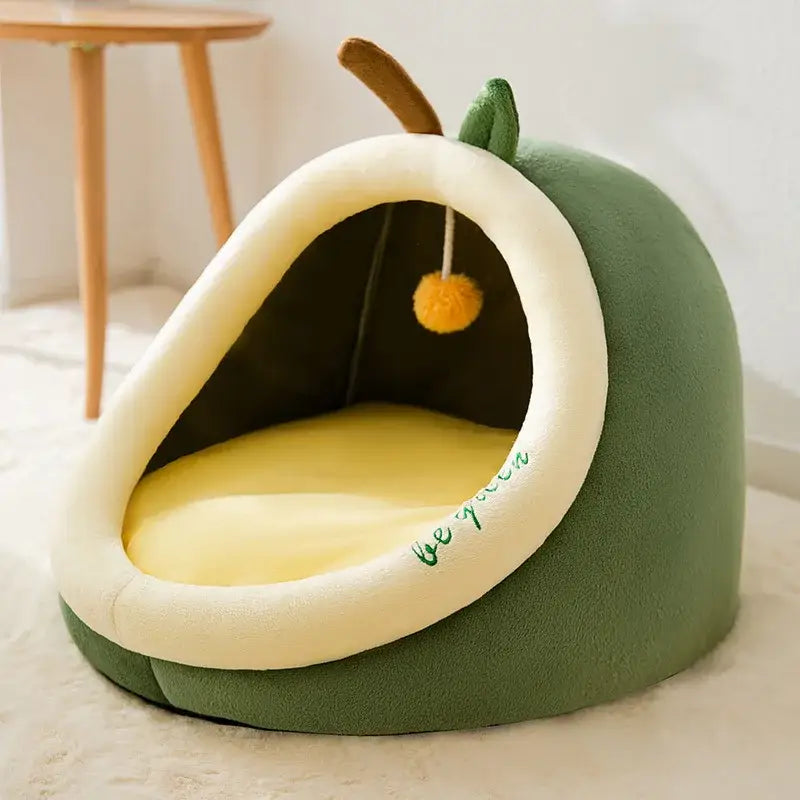 Avocado-shaped pet bed with a yellow interior and a dangling toy.