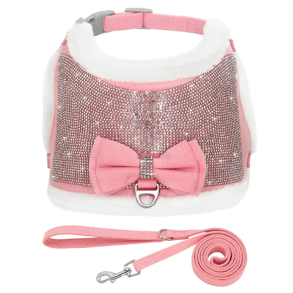 Pink and rhinestone-studded dog harness with matching leash and decorative bow.