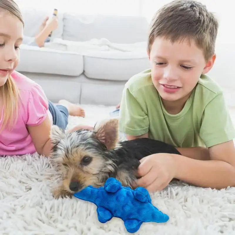 Dog lying on a fluffy rug with two children and a blue toy.