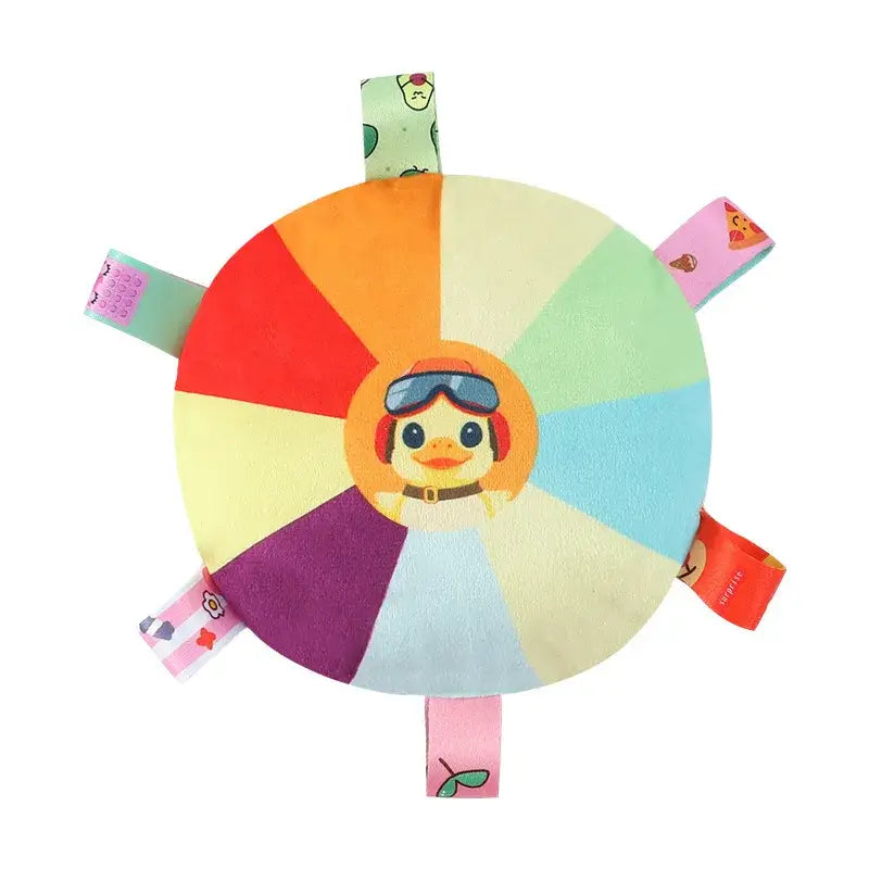 Colorful circular plush toy with a cartoon character face in the center and fabric tags around the edges.