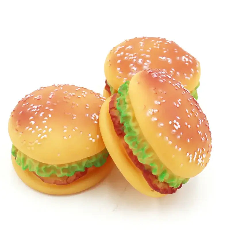 Plastic toy hamburgers with sesame seed buns, lettuce, and patties.