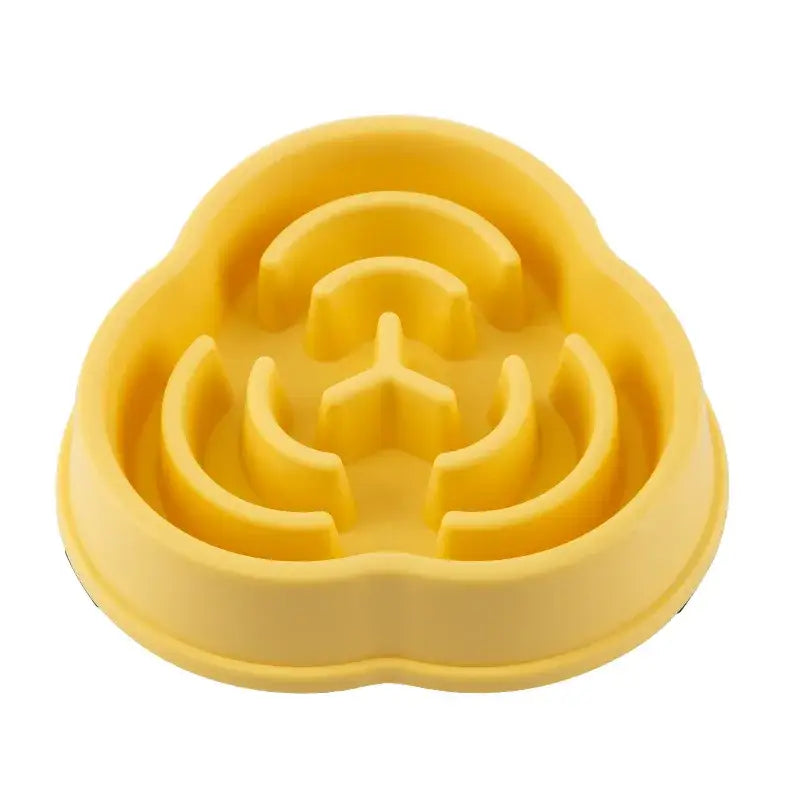 Yellow plastic pet food bowl with a raised maze-like pattern inside.