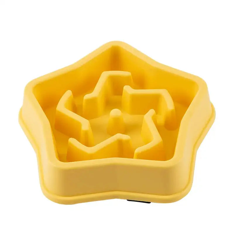 Yellow star-shaped plastic mold or dish with an intricate maze-like interior pattern.