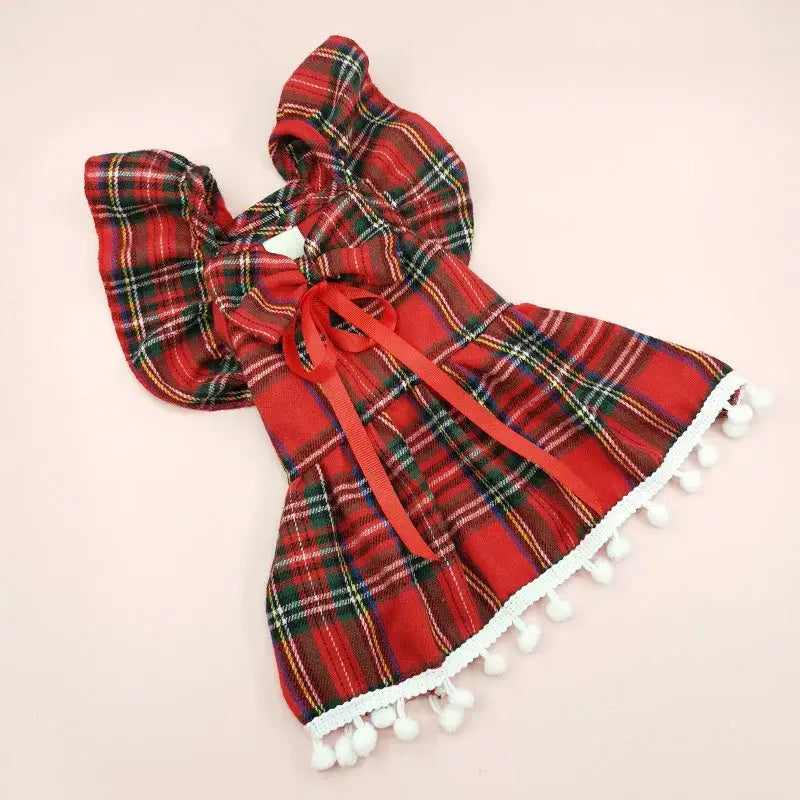 Red plaid dress with a hood and white pom-pom trim.