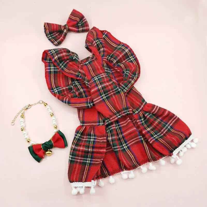 Red plaid dress with white pom-pom trim and matching hair bow.