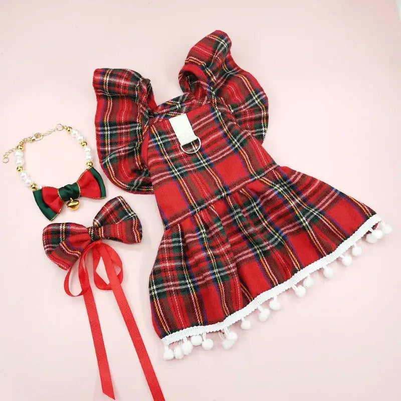 Red plaid dress with white pom-pom trim and ruffled sleeves.