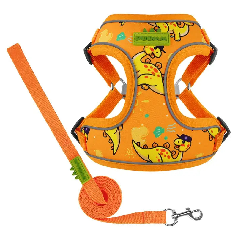 Bright orange dog harness with cartoon dinosaur print and matching leash.