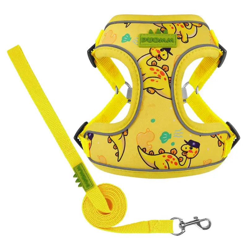 Yellow dog harness with cartoon dinosaur print and matching leash.