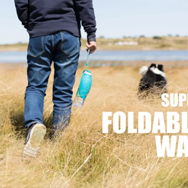 Foldable water bottle carried by a person walking through a grassy field.