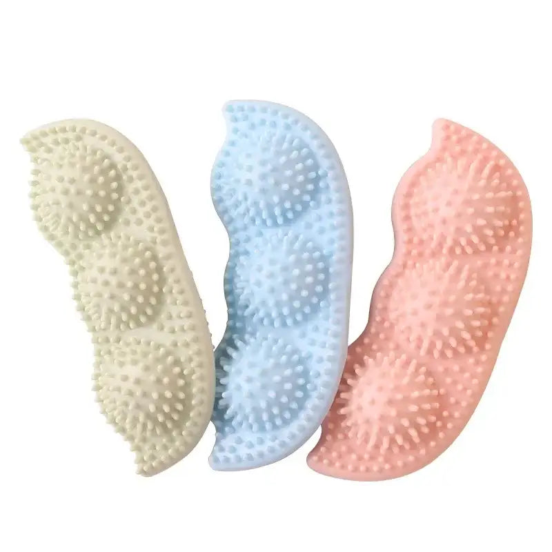 Textured silicone massage tools in pastel yellow, blue, and pink colors.