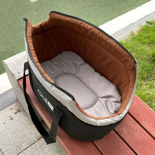 Pet carrier or travel bed with a padded interior and carrying handles.