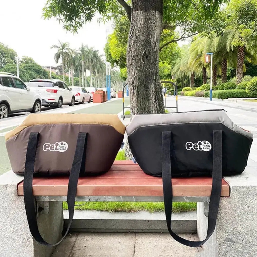 Two pet carrier bags sitting on a bench.