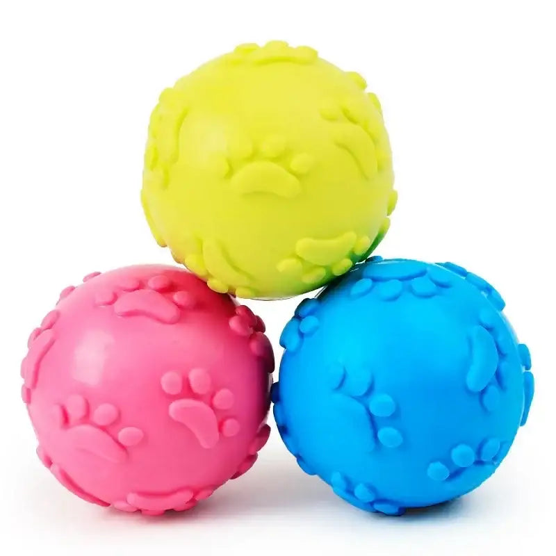 Three colorful rubber dog balls with paw print textures.