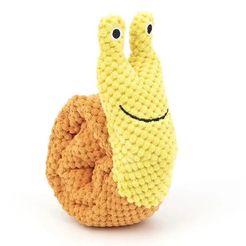 Crocheted yellow and orange snail toy with a smiling face.