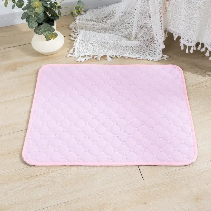 Pale pink rectangular bath mat or rug with a textured surface.