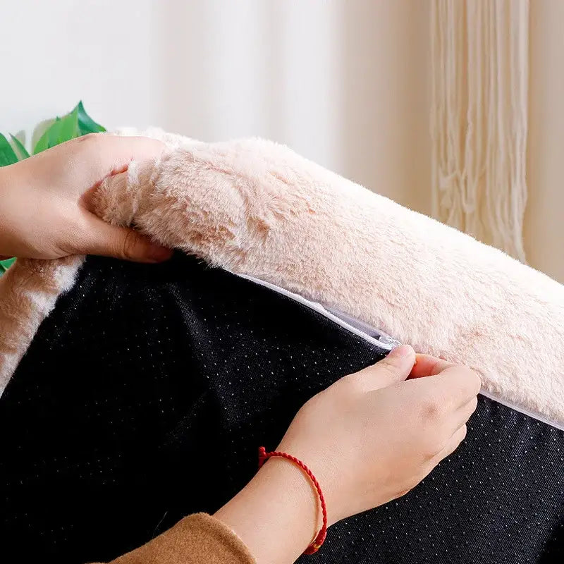 Fluffy pink cushion or pillow cover being placed over a black base.