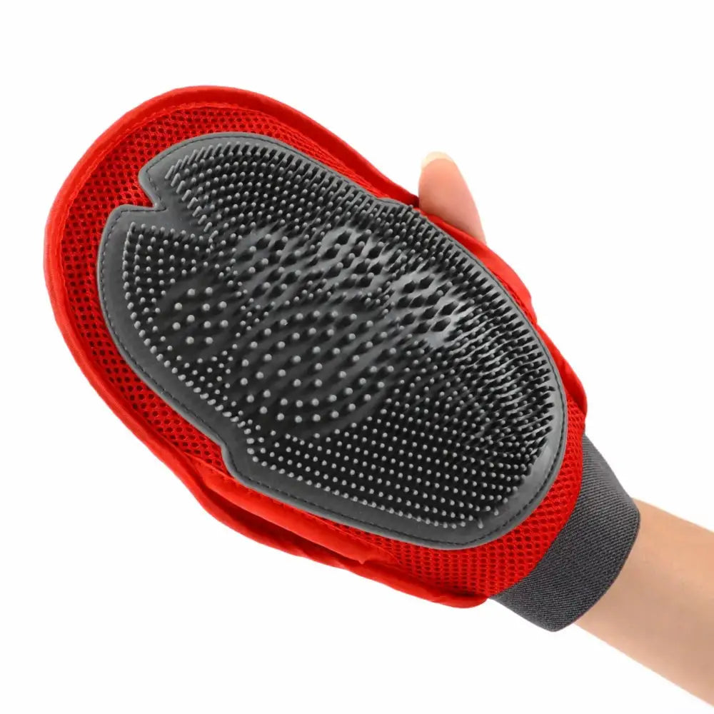 Pet grooming glove with rubber bristles and a red fabric backing worn on a hand.