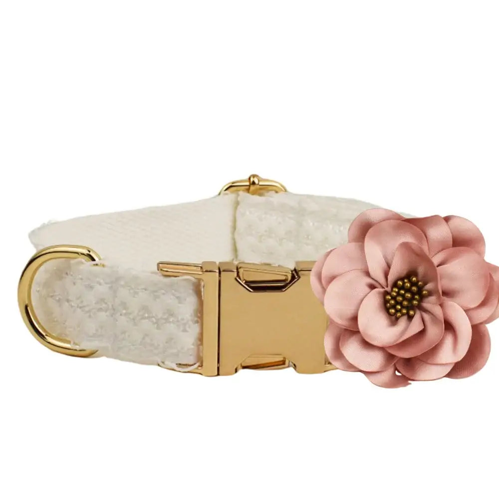 Decorative dog collar with a white fabric base, gold hardware, and a pink flower accent.