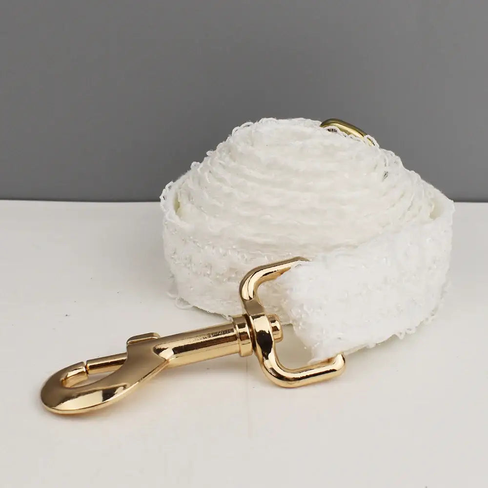 White cotton or fabric leash with a gold-toned metal clasp.