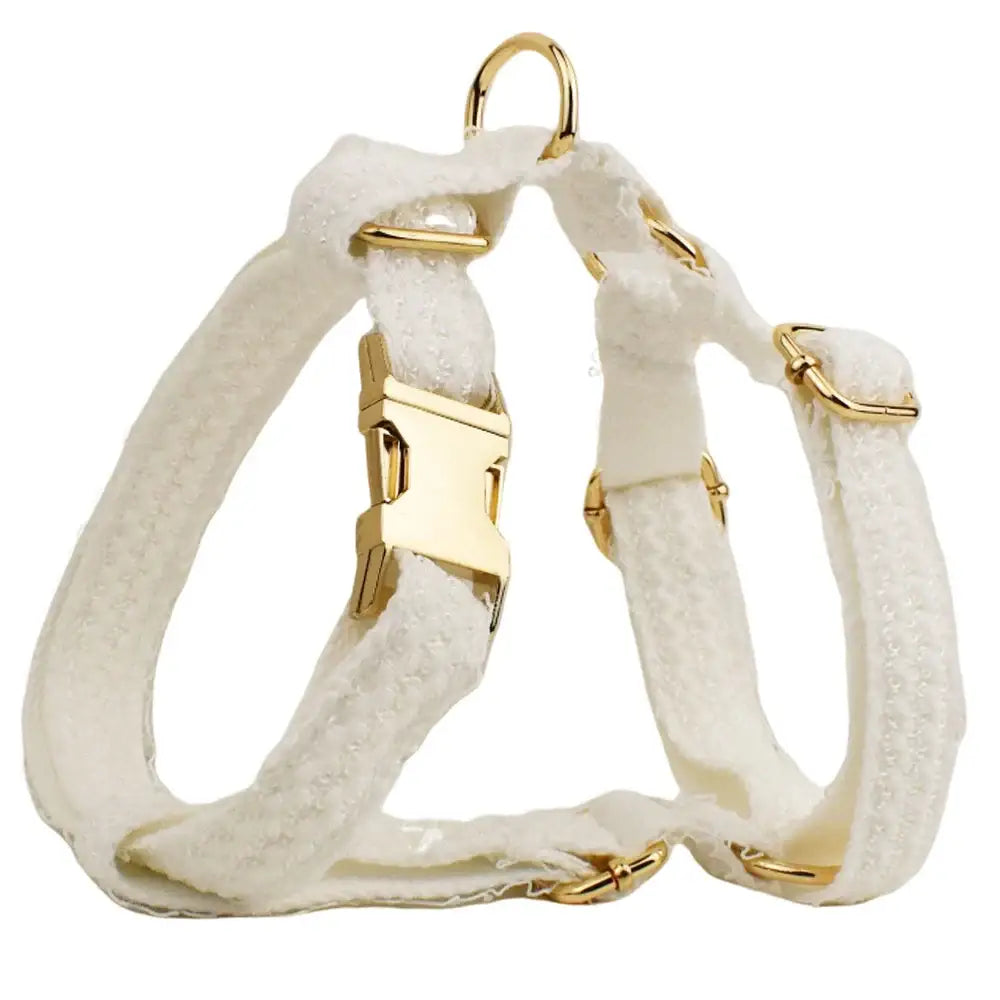 White fabric dog harness with gold-colored metal hardware.