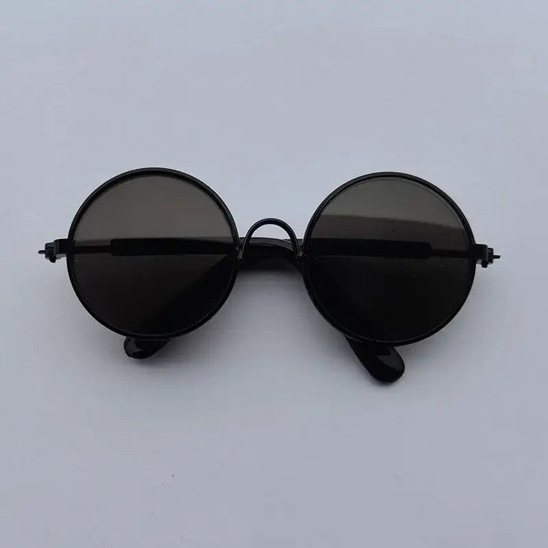 Pair of round, black sunglasses with dark lenses.