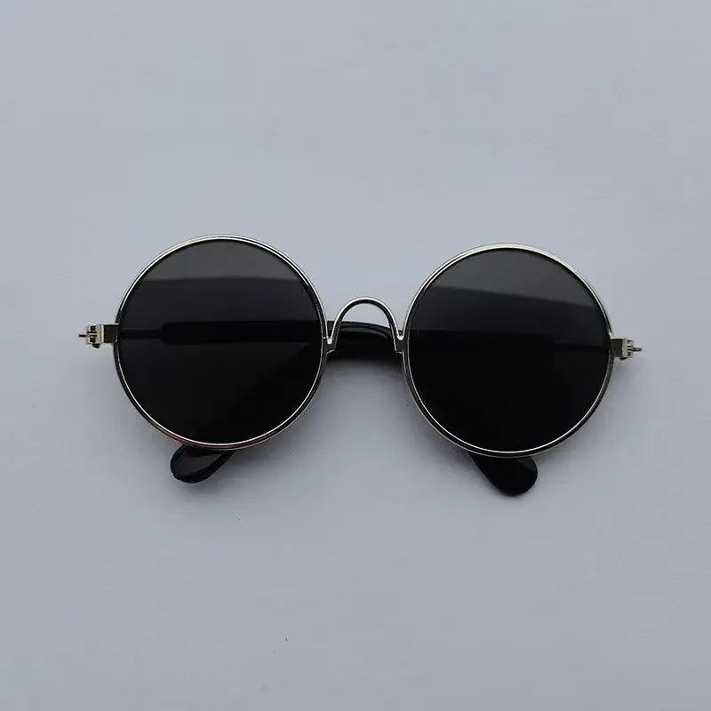 Pair of round, dark-lensed sunglasses with a silver metal frame.