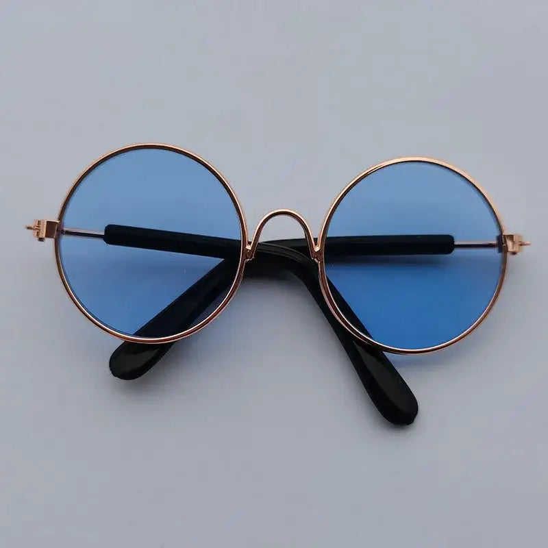 Pair of round sunglasses with blue lenses and gold frames.