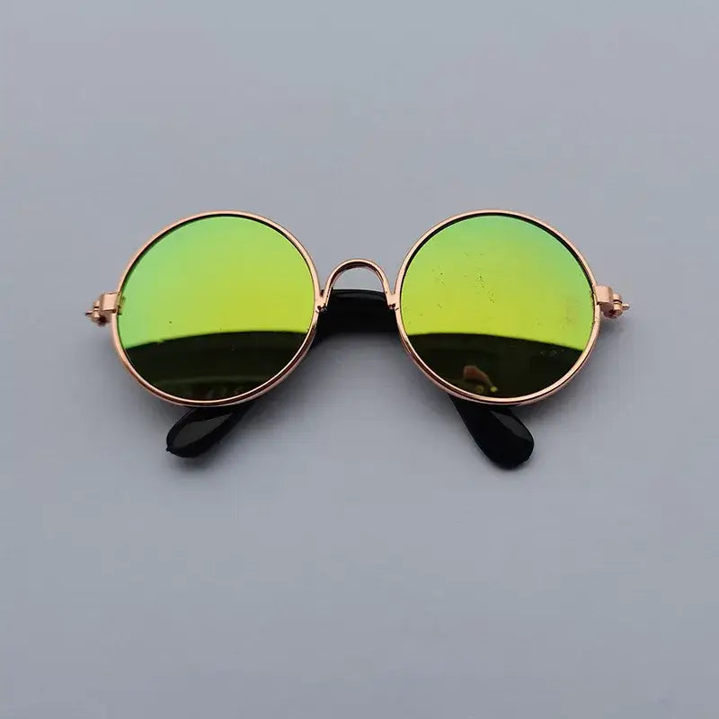 Round sunglasses with green-tinted lenses and gold frames.