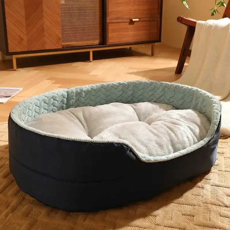 Oval-shaped pet bed with a navy blue exterior and light blue quilted interior lining.